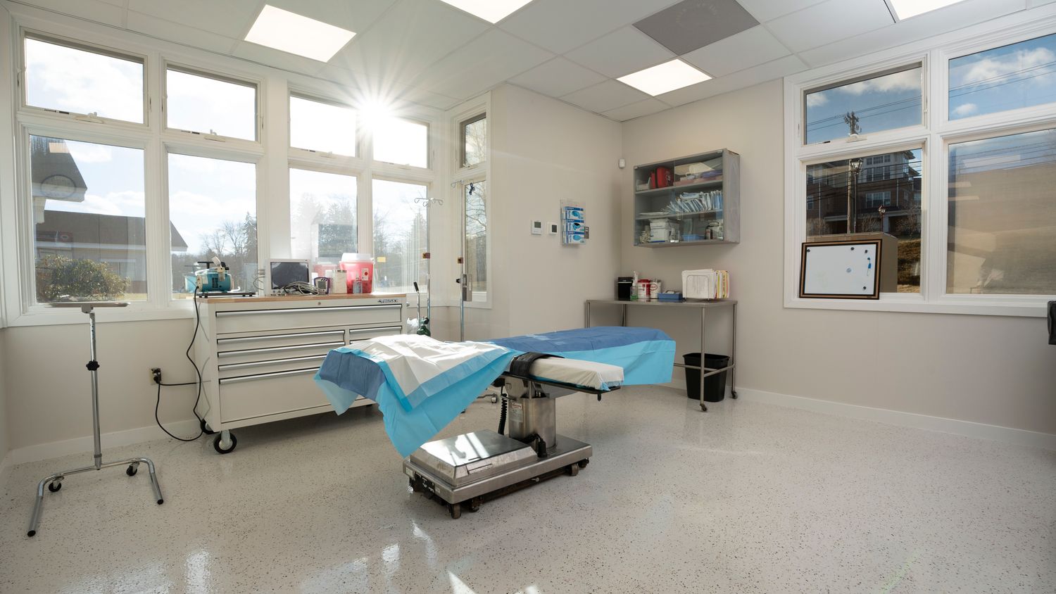 Bright, clean surgical room with equipment and windows.