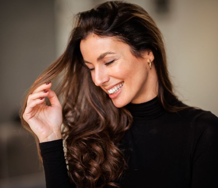 Smiling woman with long, flowing hair.
