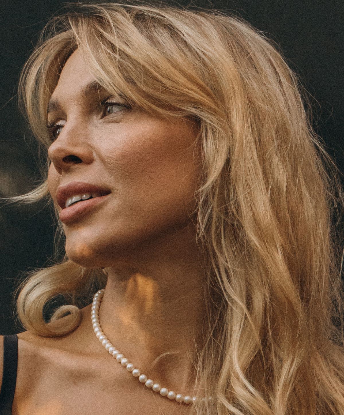 Avon chin augmentation model with wavy blonde hair wearing pearls