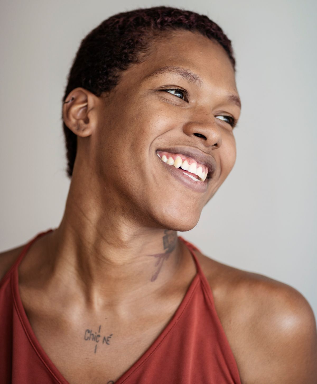 Farmington FFS model with short hair and tattoos.