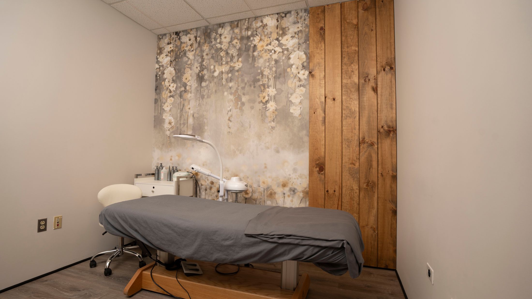 Spa treatment room with floral wallpaper and wood accents.
