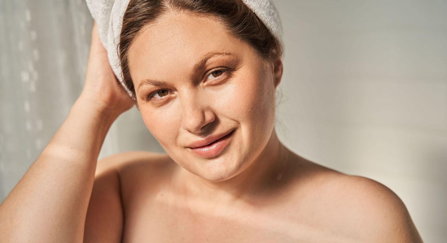 Woman with towel, natural skincare routine at home.